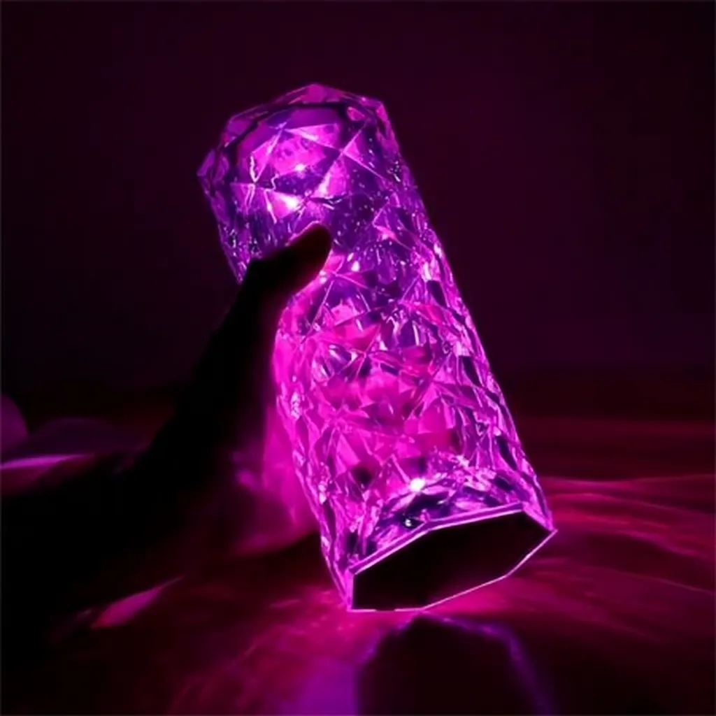 Crystal diamond LED lamp glowing purple light in hand