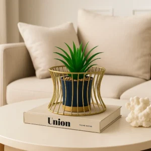 Tall golden wire-frame planter with artificial green plant in black pot